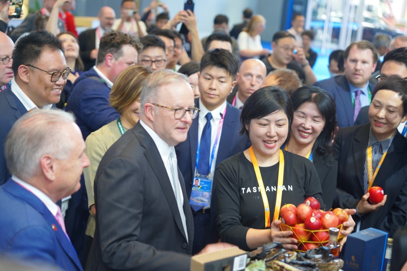 Prime Minister Anthony Albanese and Don Farrell, Minister for Trade with Vivian Zhao and a basket of Tasmanian Tiger Fuji apples.